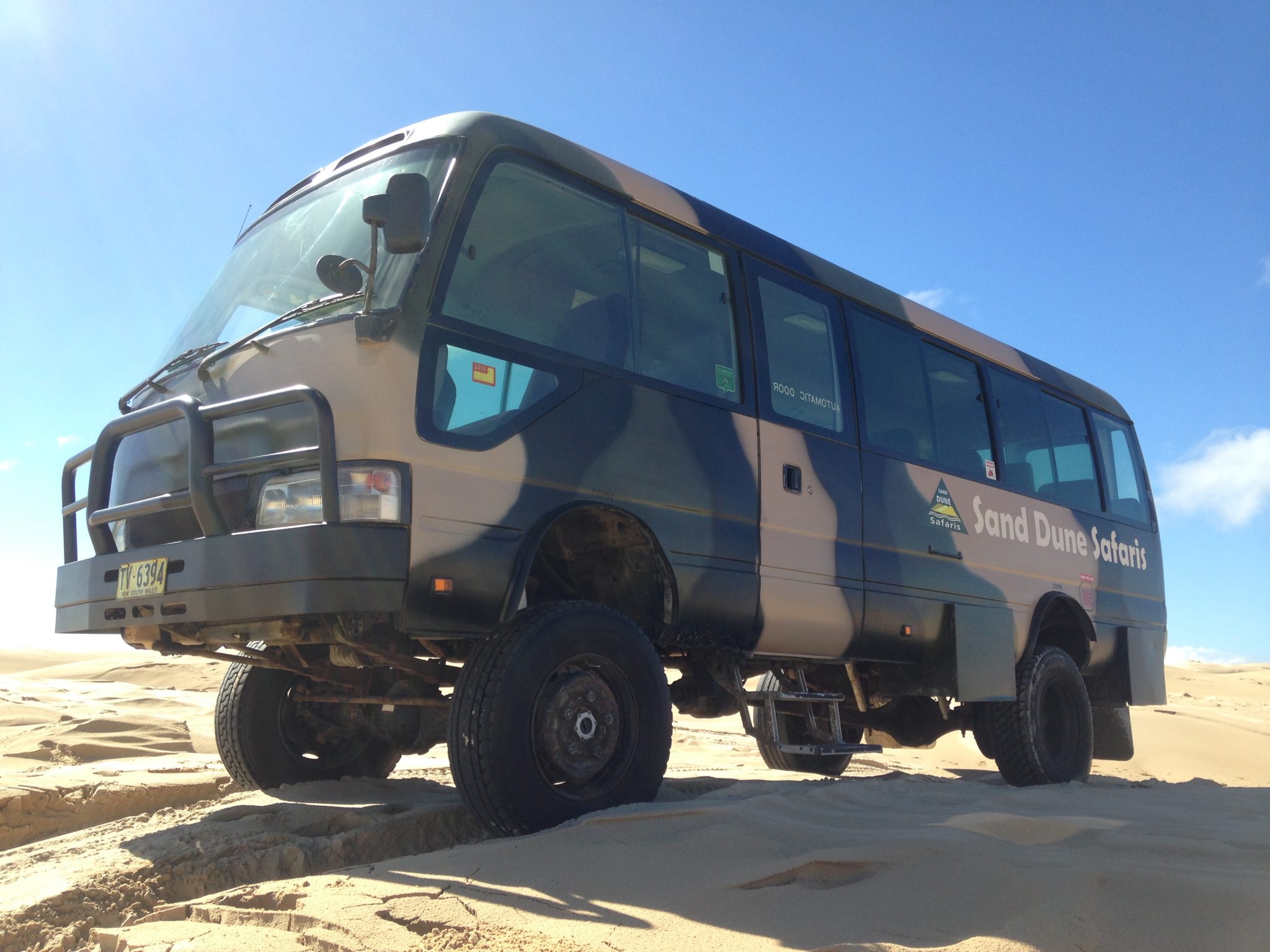 a truck driving down a sand road