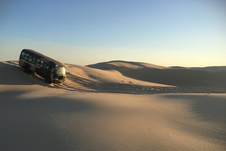 a van driving down a sand dune