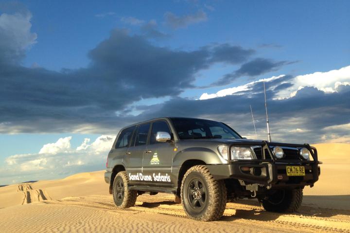 a truck driving down a sandy road